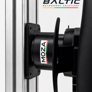 May include: A black Moza racing wheel base mounted to a silver aluminium profile rig. The unit features a black cylindrical housing with the text MOZA and a tricolour stripe. Above, the text BALTIC MOTORSPORT SOLUTIONS is visible with a tricolour line.