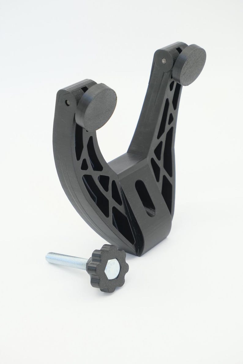 Pu&ograve; includere: Staffa nera stampata in 3D con un design curvo e ritagli geometrici. Presenta due cuscinetti circolari e una manopola filettata con impugnatura a forma di stella. La staffa &egrave; progettata per contenere un oggetto.