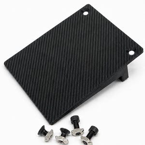 May include: A rectangular black carbon fiber plate with a visible weave pattern and two circular mounting holes at the top edge. The plate is accompanied by four small metal T-slot bolts with black heads. The text BALTIC MOTORSPORT SOLUTIONS is below.