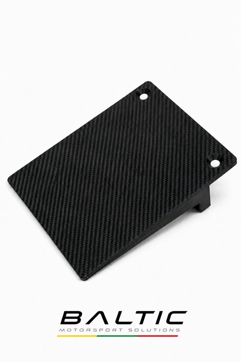 May include: A rectangular black carbon fiber panel with a woven texture, featuring two countersunk mounting holes along one edge and a perpendicular support bracket on the underside. The text BALTIC MOTORSPORT SOLUTIONS is printed below.
