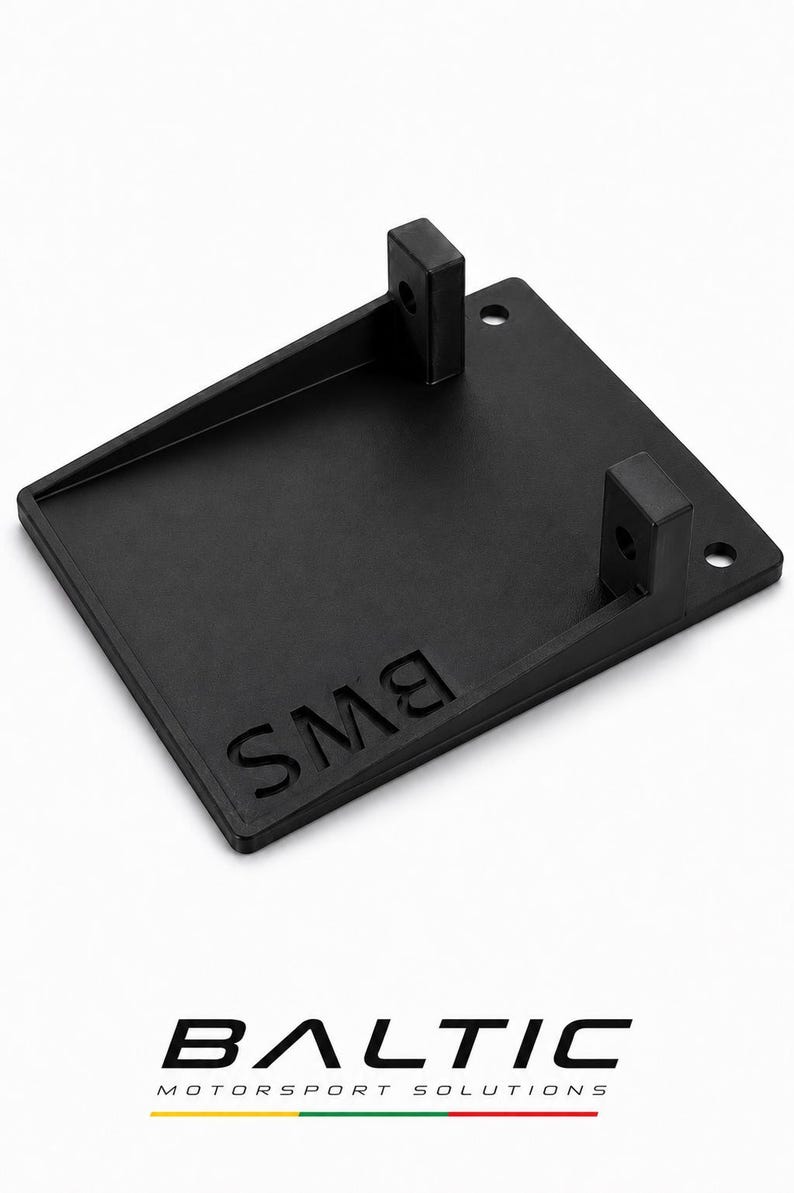 May include: A black, rectangular, flat mounting bracket featuring two vertical tabs with circular holes, two additional circular holes on the base, and the embossed text "BMS" on the surface. The logo "BALTIC MOTORSPORT SOLUTIONS" appears below.