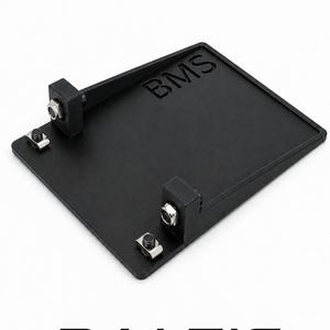 May include: A rectangular black metal mounting plate featuring the embossed text BMS. The plate includes two raised black brackets, each secured with a silver-colored metal bolt and nut, along with two additional silver-colored metal fasteners on the base.