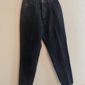 May include: Black high-waisted jeans with a straight leg fit.