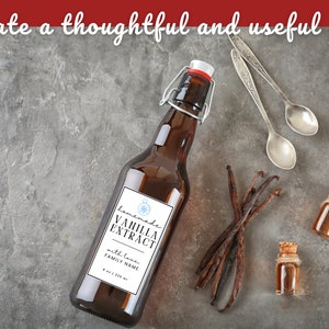 May include: A brown glass bottle with a white label that reads "Homemade Vanilla Extract with love, FAMILY NAME" and a compass design. The bottle is sitting on a gray surface with vanilla beans, two small bottles of vanilla extract, and two silver spoons.