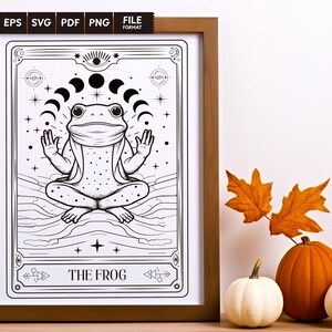 May include: A black and white illustration of a frog sitting in a meditative pose with a crescent moon above its head. The image is framed in a brown wooden frame and has the text "THE FROG" at the bottom.