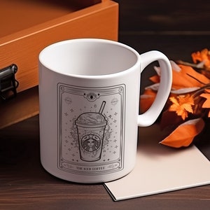 May include: White ceramic mug with a black and white illustration of an iced coffee drink with the text "The Iced Coffee" on the front.