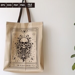 May include: A beige tote bag with a black and white illustration of a skull with flowers and the text "The Plant Lover".