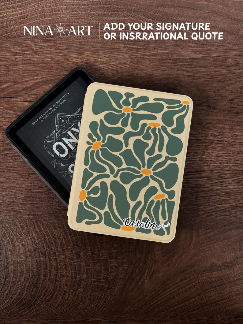 May include: A deck of cards with a floral design in shades of green and orange on a cream background. The name "Caroline" is printed on the bottom. The deck is next to a black box with the text "ONYX". The top left corner has the text "NINA ART".