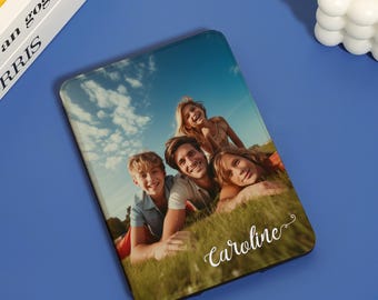May include: A personalized phone case with a photo of a family of four smiling and lying on the grass. The name "Caroline" is written in cursive on the bottom of the case.