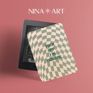 May include: A black e-reader with a cover featuring a green and beige checkered pattern. The cover has the text "FUCK OFF I'M READING" in green. The image also includes the text "NINA ART" in white.