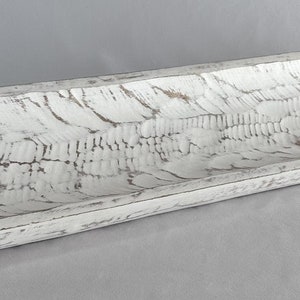 May include: A long, white wooden dough bowl with a distressed finish. The bowl is perfect for serving bread, fruit, or other snacks.