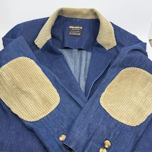 May include: A blue denim blazer featuring a tan corduroy collar and matching tan corduroy elbow patches. The jacket includes three brown buttons on each sleeve cuff and a label inside the collar reading George Masket Ltd. New York, NY.