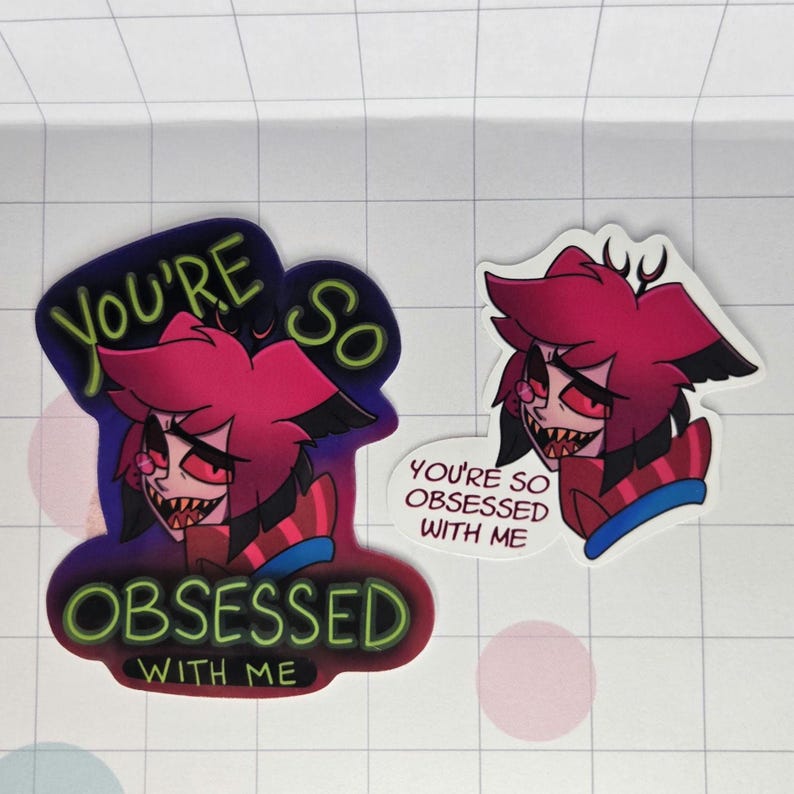 May include: Two stickers featuring a cartoon character with red hair, black accents, and a sinister grin. One sticker reads "YOU'RE SO OBSESSED WITH ME" in green and white. The other says "YOU'RE SO OBSESSED WITH ME".