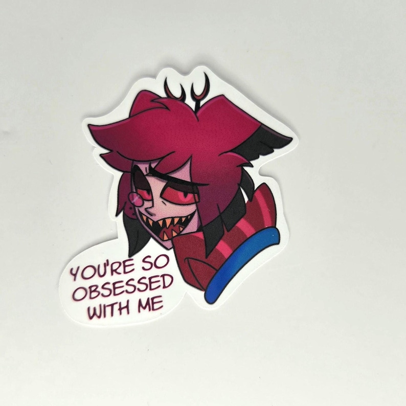 May include: A sticker featuring a cartoon character with red hair, black accents, and a sinister grin. The character is wearing a red and black striped outfit. Text on the sticker reads "YOU'RE SO OBSESSED WITH ME."