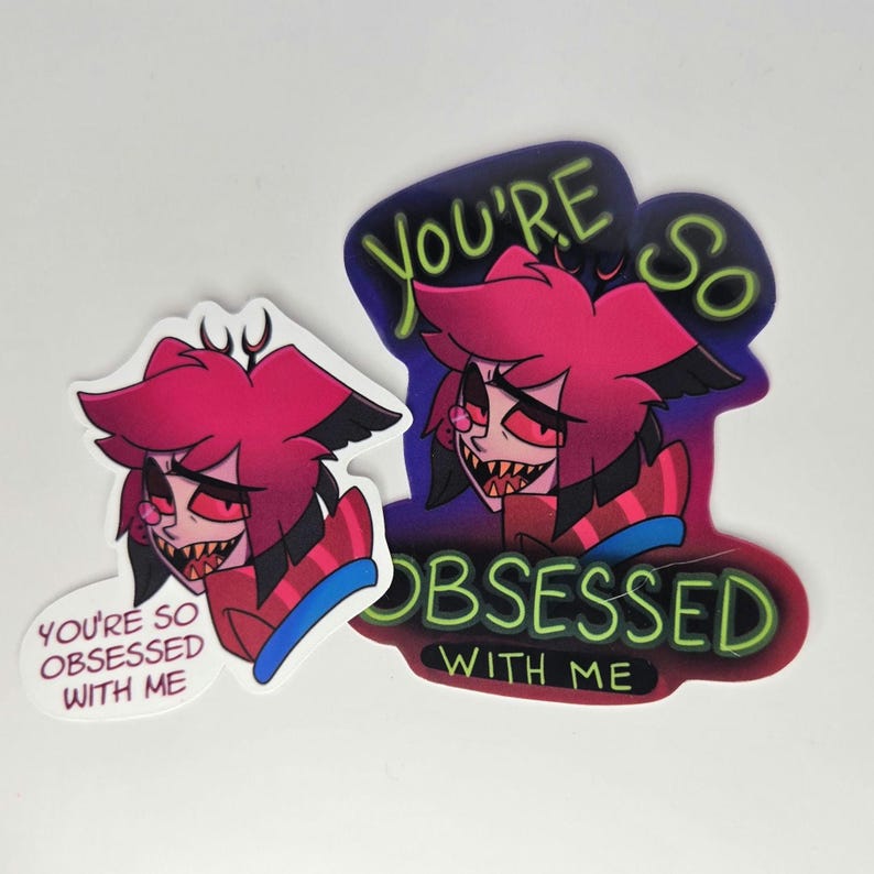 May include: Two stickers featuring a cartoon character with red hair, black ears, and a sinister grin. One sticker says "You're so obsessed with me." The other says "You're so obsessed with me" in a larger font.