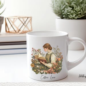 Puede incluir: Taza de caf&eacute; de cer&aacute;mica blanca con un dise&ntilde;o floral y una mujer leyendo un libro. La taza tiene el texto "Coffee Lover" en la parte inferior.