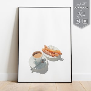 May include: A framed print featuring a cup of coffee on a saucer with a spoon, and a plate of churros with a small dish of dipping sauce. The image has a white background and a black frame. The text "instant DOWNLOAD + PRINT at home" is in the upper right corner.