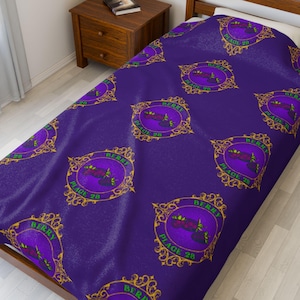 May include: A purple bedspread with a repeating pattern of a circular design with the words "BERRY PLACE 28" in green and gold. The design features a purple berry and green leaves.