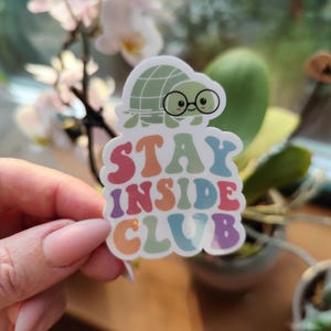 May include: A white sticker with a cartoon turtle wearing glasses and the text "Stay Inside Club" in rainbow colors.