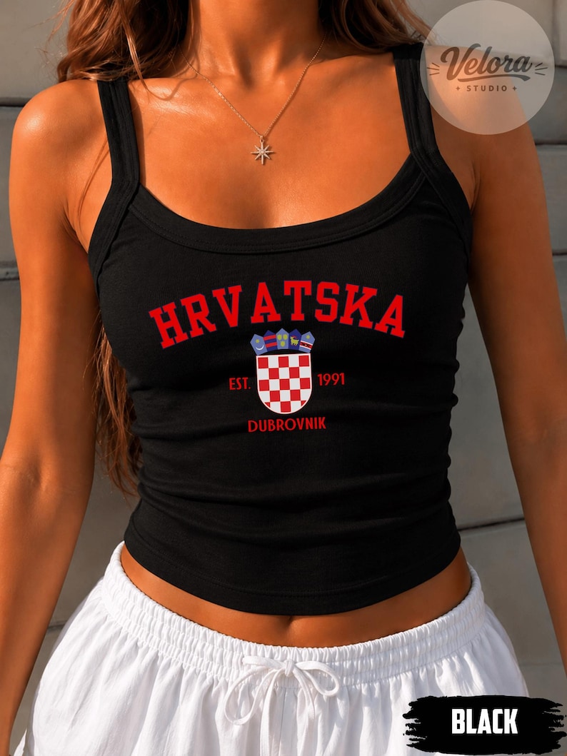 May include: A black ribbed tank top featuring the red text HRVATSKA in an arched font above a red and white checkered coat of arms. The design includes the red text EST. 1991 and DUBROVNIK positioned around the central emblem on the chest.