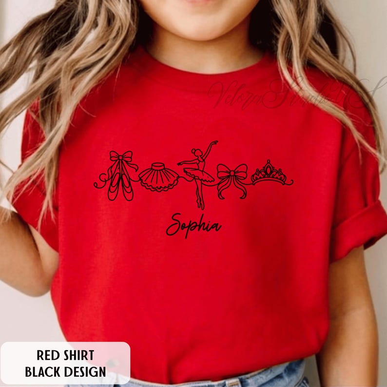 Puede incluir: Una camiseta roja con un dise&ntilde;o negro que presenta ilustraciones de ballet: zapatillas de punta, un tut&uacute;, una bailarina, un lazo y una tiara. El nombre "Sophia" est&aacute; escrito debajo. El texto "RED SHIRT BLACK DESIGN" est&aacute; en un rect&aacute;ngulo blanco.