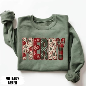 Könnte beinhalten: Ein militärgrüner Rundhals-Pullover mit dem Wort MERRY in großen Blockbuchstaben auf der Brust. Jeder Buchstabe zeigt ein einzigartiges Weihnachtsmuster, darunter Weihnachtssterne, Schneeflocken, Punkte, Tannenbäume und ein rotes Schottenkaro.