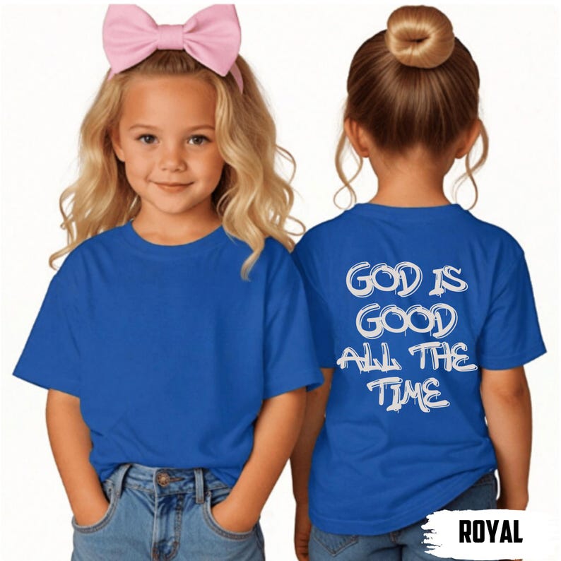 May include: Two young girls wearing royal blue t-shirts. The front of the shirt is plain, while the back of one shirt displays the text "GOD IS GOOD ALL THE TIME" in white. One girl wears a pink bow.