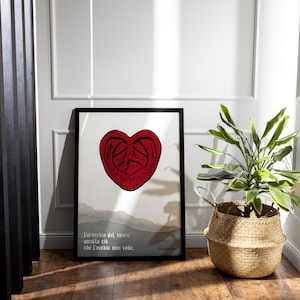 Può includere: Una stampa incorniciata con un'illustrazione di cuore rosso e il testo "L'orecchio del cuore ascolta ciò che l'occhio non vede." La stampa è su sfondo bianco ed è incorniciata in nero.