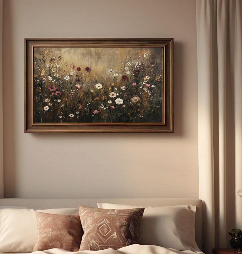 Puede incluir: Una pintura enmarcada de un campo de flores silvestres en tonos de blanco, rosa y morado. El fondo es un dorado suave y apagado.