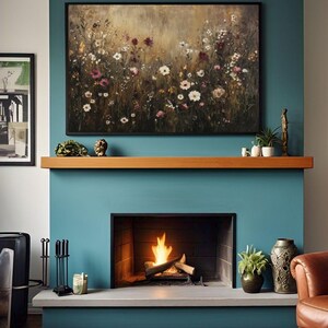 Puede incluir: Una pared azul turquesa con una repisa de madera sobre una chimenea. La chimenea tiene un marco negro y un fuego ardiendo en su interior. Un cuadro de un campo de flores silvestres cuelga sobre la repisa.