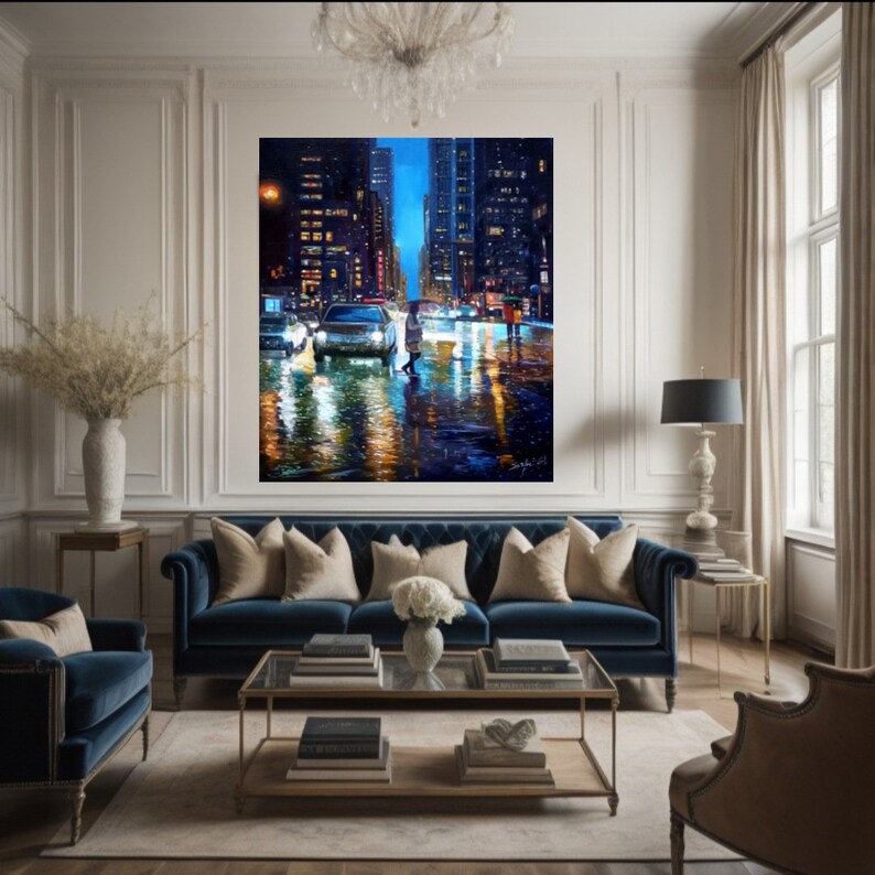 May include: A painting of a city street at night with cars and people walking in the rain. The buildings are tall and lit up with lights. The street is wet and reflecting the lights. The painting is in a modern living room with a blue sofa and a coffee table.