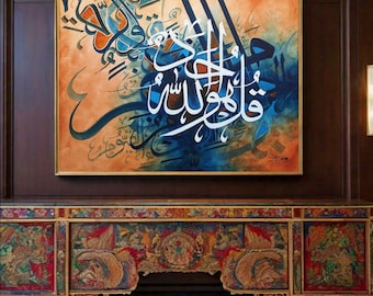 May include: A large, framed painting with Arabic calligraphy in blue, white, and gold on a brown and orange background. The painting is hanging above a colorful, ornate wooden cabinet.