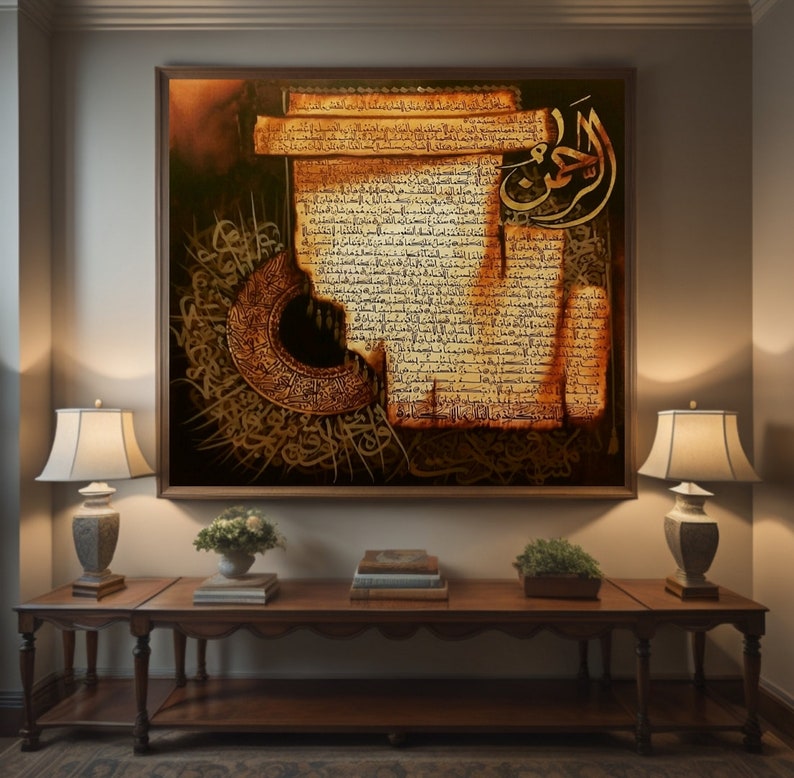 May include: A framed artwork with gold and brown Arabic calligraphy. The artwork shows detailed script on a parchment-like background, with ornate embellishments and a crescent moon design. The artwork is displayed above a wooden console table.