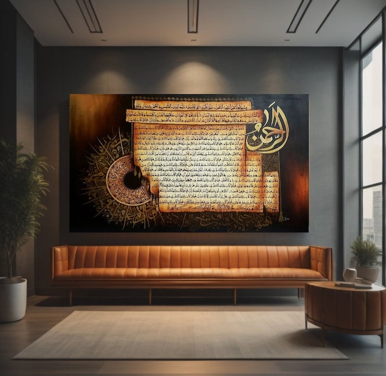 May include: A large rectangular artwork with gold Arabic calligraphy on a dark backdrop. The artwork has a vintage, aged paper appearance with intricate patterns and text. It hangs above a brown leather sofa in a modern living room setting.