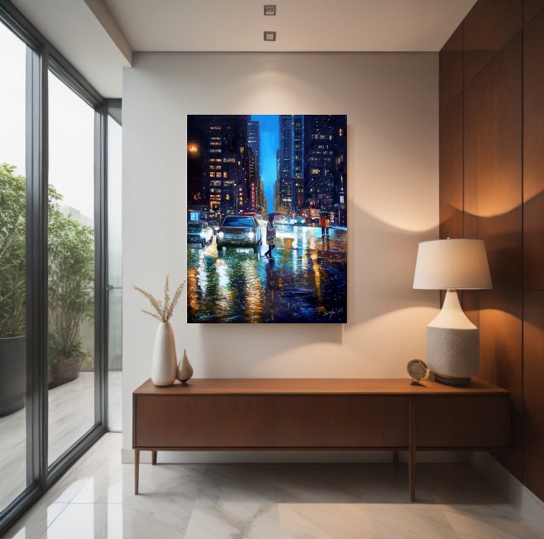 May include: A painting of a city street at night with a person walking in the rain. The street is wet and reflective, and the buildings are lit up. The painting is done in a realistic style and has a warm, inviting feel.