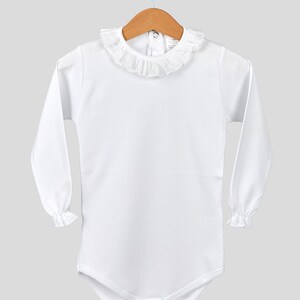 May include: White long-sleeve baby bodysuit with a ruffled collar and a snap closure at the bottom.