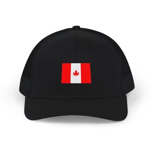 May include: A black trucker hat featuring a structured front panel and a breathable mesh back. The center of the front panel displays a rectangular Canadian flag graphic with two red vertical bars and a white center containing a red maple leaf.