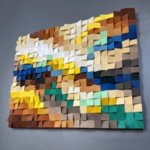 Peut inclure: Une œuvre d'art murale composée de blocs de bois dans différentes nuances de brun, jaune, vert, bleu et blanc. Les blocs sont disposés selon un motif géométrique, créant un design texturé et abstrait.