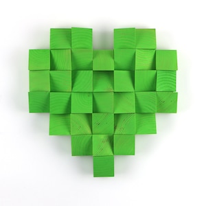Puede incluir: Una decoración de pared en forma de corazón verde hecha de cuadrados de madera.