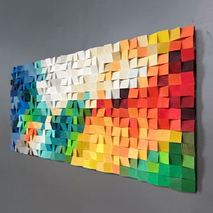 Puede incluir: Una pieza de arte de pared colorida hecha de madera, con un patrón geométrico de cuadrados y triángulos en tonos de azul, verde, amarillo, naranja y rojo.