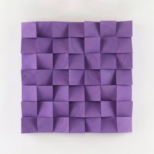 Peut inclure: Une œuvre d'art murale composée de carrés en bois, chacun peint d'une couleur violet clair. Les carrés sont disposés en grille, chaque carré étant légèrement décalé par rapport au suivant. Le grain du bois est visible sur chaque carré.