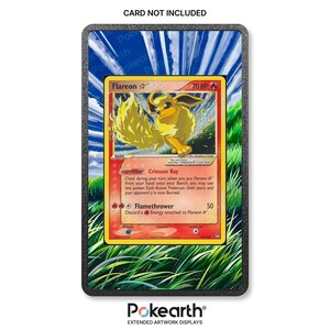 Peut inclure: Un cadre d'affichage noir rectangulaire contenant une carte à collectionner Flareon avec 70 PV, le pouvoir Crimson Ray et l'attaque Flamethrower. L'arrière-plan montre de l'herbe verte et un ciel bleu. Le texte CARD NOT INCLUDED est imprimé en haut.