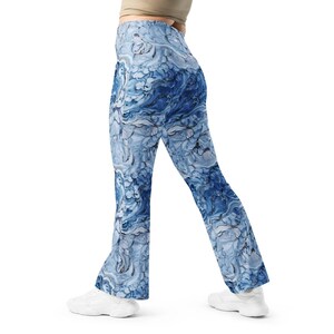 May include: High-waisted flared leggings featuring an abstract marble-like pattern in shades of navy blue, light blue, and white. The leggings have a fitted waist and hip area that transitions into a flared leg silhouette, paired with white sneakers.