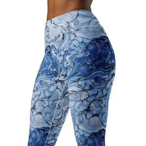 May include: High-waisted leggings featuring a fluid, marbled pattern in shades of deep navy, royal blue, and white. The fabric displays swirling, organic shapes that resemble liquid paint or stone textures, covering the entire surface of the garment.
