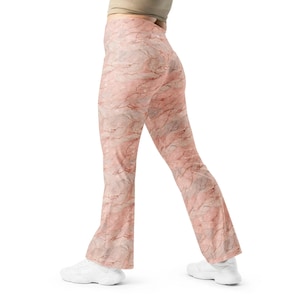 May include: A pair of pink and white marble print flared leggings. The leggings are made of a stretchy, comfortable fabric and are perfect for yoga, running, or just lounging around the house.
