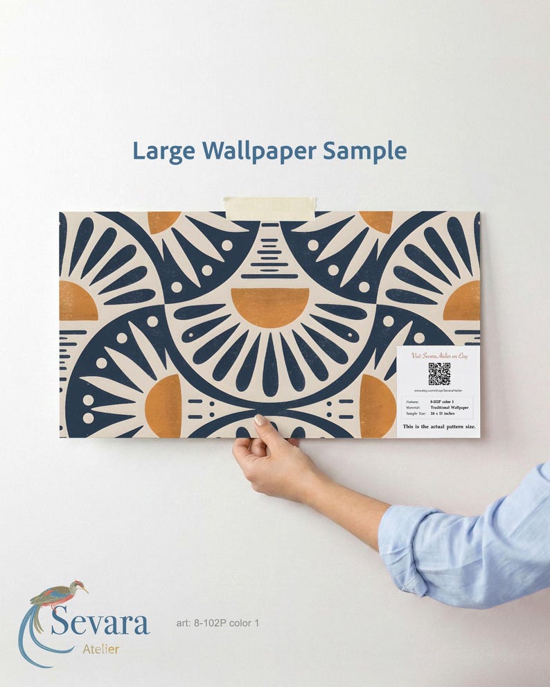 May include: A large wallpaper sample featuring a repeating geometric pattern of dark blue fan shapes and orange semi-circles on a cream background. The sample includes a white label with a QR code, text, and the dimensions 28 x 22 inches.