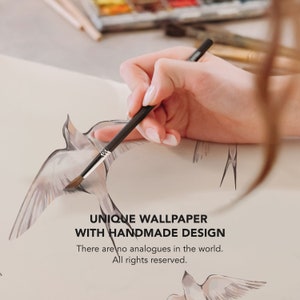 May include: A hand holding a paintbrush, painting a watercolor design of birds on a white paper. The text "UNIQUE WALLPAPER WITH HANDMADE DESIGN" is written below the birds. The text "There are no analogues in the world. All rights reserved." is written below the first text.