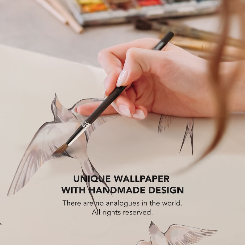 May include: A hand holding a paintbrush, painting a watercolor design of birds on a white paper. The text "UNIQUE WALLPAPER WITH HANDMADE DESIGN" is written below the birds. The text "There are no analogues in the world. All rights reserved." is written below the first text.