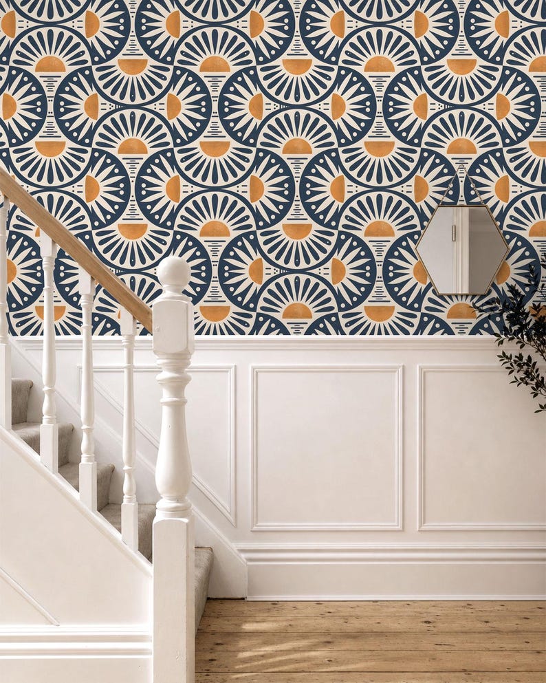 May include: Wallpaper featuring a repeating geometric pattern of dark blue and white semicircles with orange sun-like accents. The design is applied to a wall above white wainscoting, adjacent to a white wooden staircase and a small hexagonal mirror.