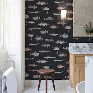 May include: Wallpaper featuring a repeating pattern of various fish illustrations in shades of grey, white, and muted pink against a solid black background. The fish are depicted in different orientations and sizes, creating a dense, layered visual effect.